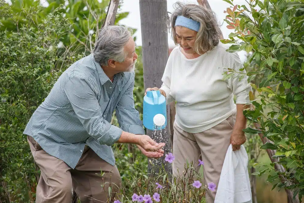 Happy,Asian,Old,Couple,Watering,The,Plants,In,The,Front