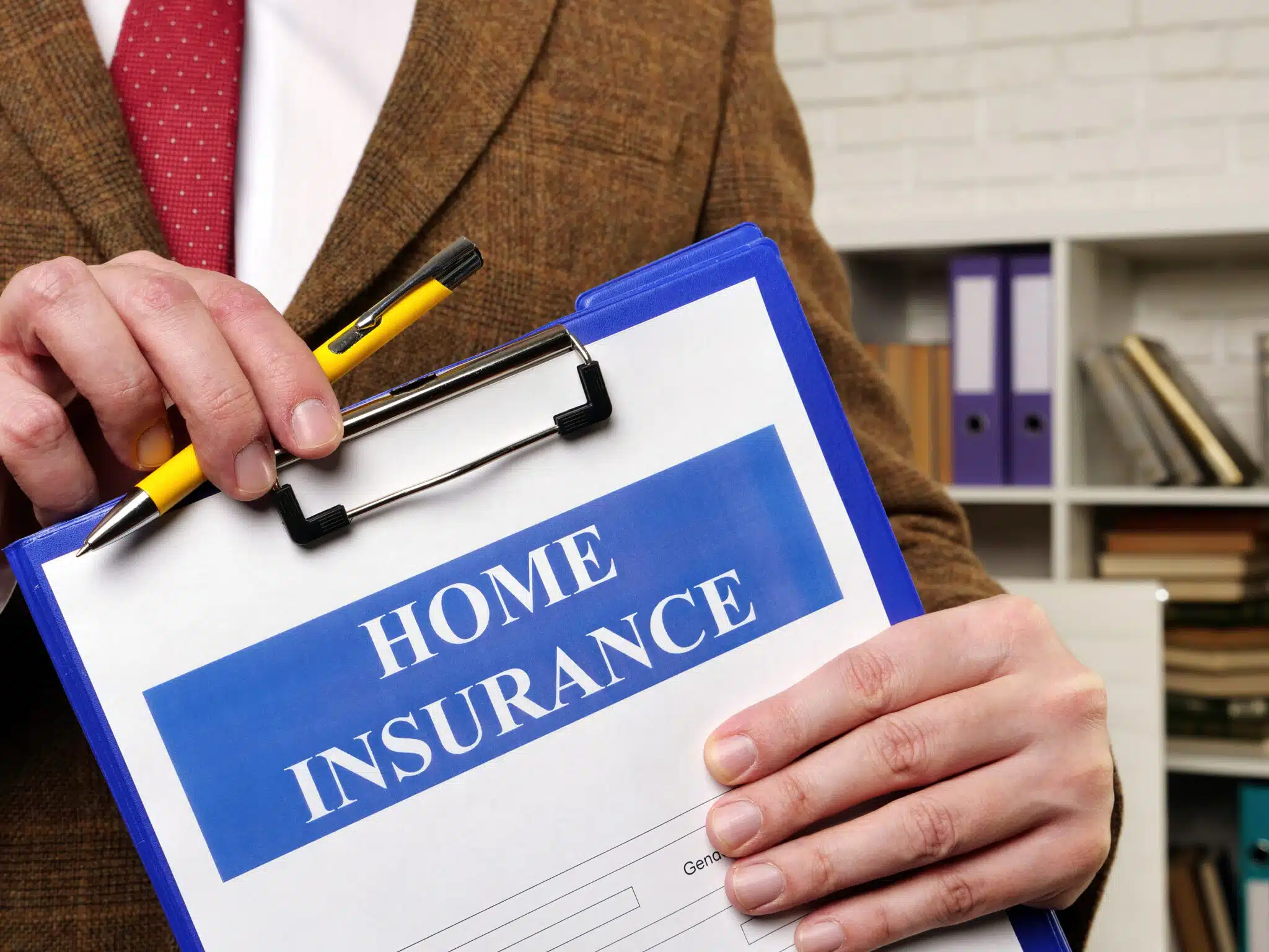 Papers about Home insurance claim and pen for filling out.
