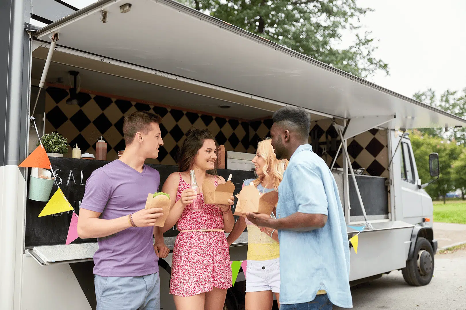 A group of friends enjoying food from a food truck that being insured with a food truck insurance.